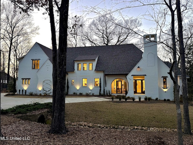 view of front of property with roof with shingles and a chimney