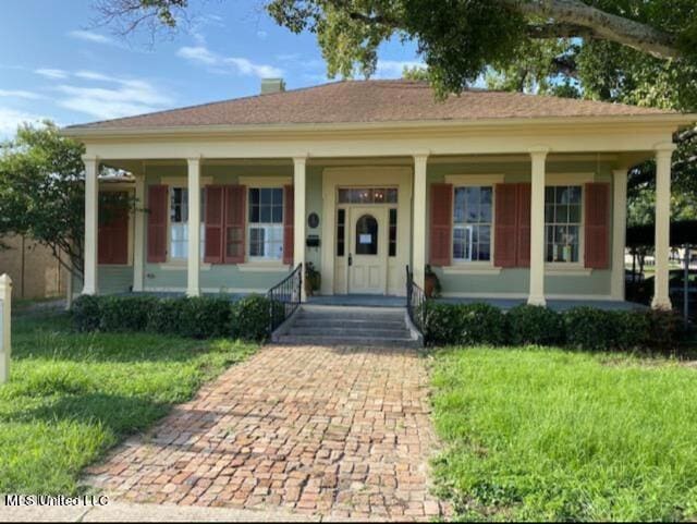 bungalow-style home featuring covered porch and a front yard