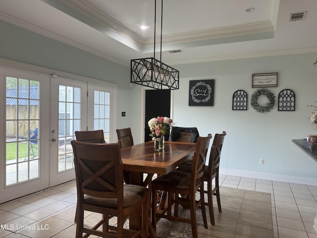 dining room with a raised ceiling, light tile patterned floors, healthy amount of natural light, and ornamental molding