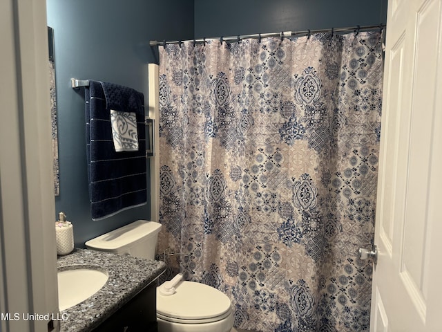 full bath featuring toilet, vanity, and a shower with curtain