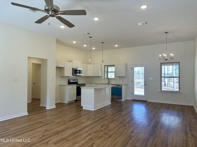 kitchen with dark wood-style floors, a kitchen island, appliances with stainless steel finishes, open floor plan, and white cabinetry