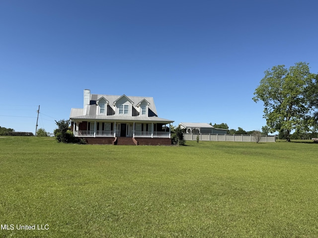 farmhouse inspired home with a front lawn, a porch, a chimney, and fence