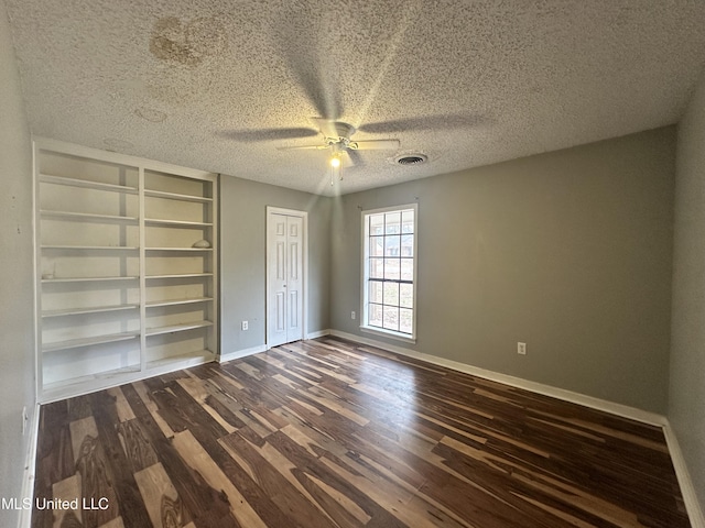 unfurnished bedroom with ceiling fan, dark wood-type flooring, and a textured ceiling