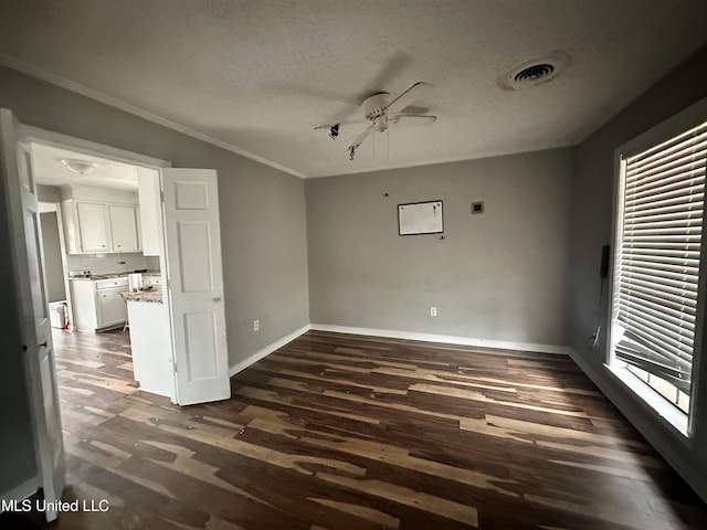 unfurnished room featuring ceiling fan, ornamental molding, dark hardwood / wood-style floors, and a textured ceiling