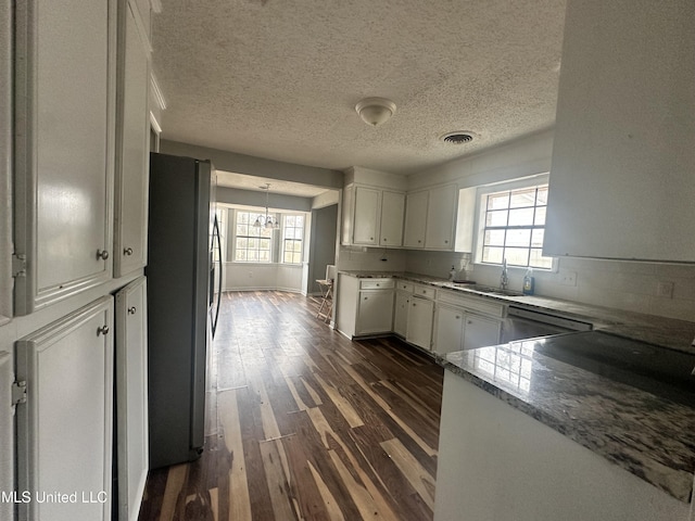 kitchen with dark hardwood / wood-style floors, white cabinetry, sink, light stone counters, and stainless steel appliances