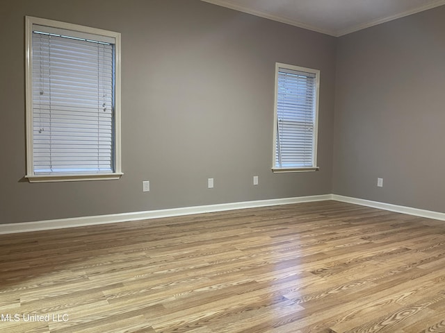 empty room featuring crown molding and light wood-type flooring