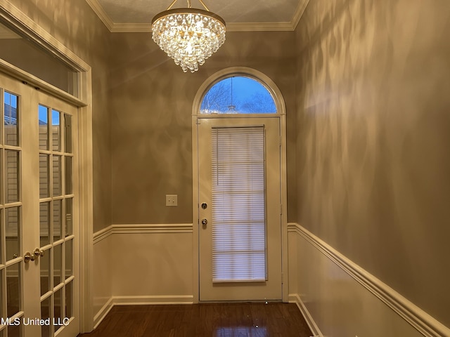 doorway featuring a chandelier, dark hardwood / wood-style flooring, and crown molding