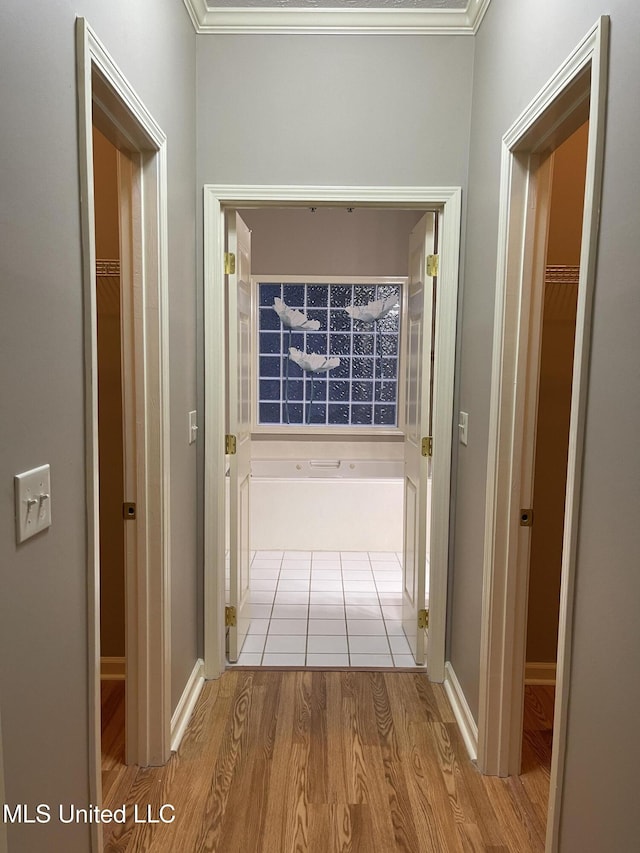 hall featuring light wood-type flooring and crown molding