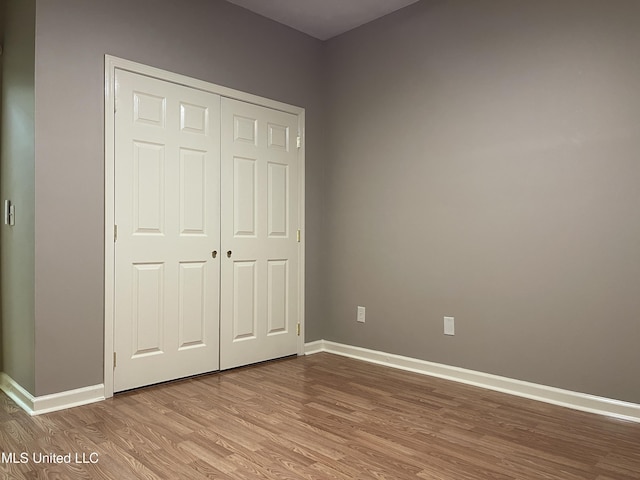 unfurnished bedroom featuring light wood-type flooring and a closet