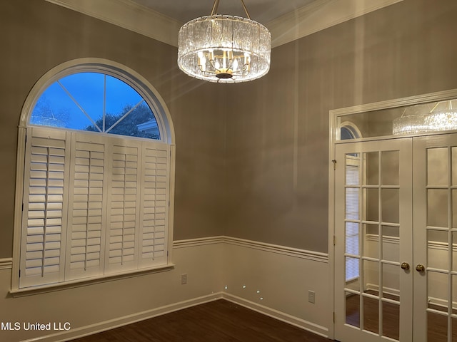 empty room featuring crown molding, a chandelier, and dark hardwood / wood-style floors