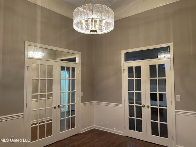 doorway with dark hardwood / wood-style flooring, crown molding, french doors, and a chandelier