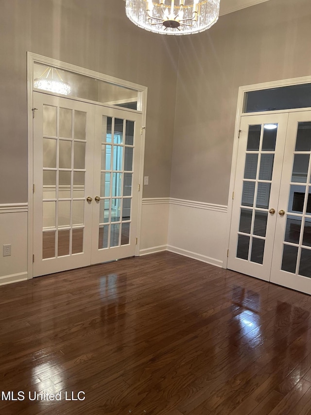 interior space with french doors, dark hardwood / wood-style floors, and a notable chandelier