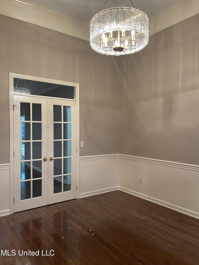 unfurnished dining area with a chandelier, french doors, dark wood-type flooring, and crown molding