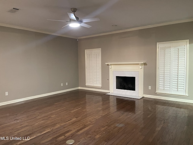 unfurnished living room featuring a tile fireplace, crown molding, ceiling fan, and dark hardwood / wood-style floors