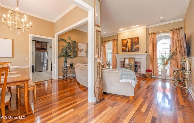 116 Hidden Hills Dr, Madison, MS 39110 - living area with light wood finished floors, a chandelier, crown molding, a fireplace, and recessed lighting