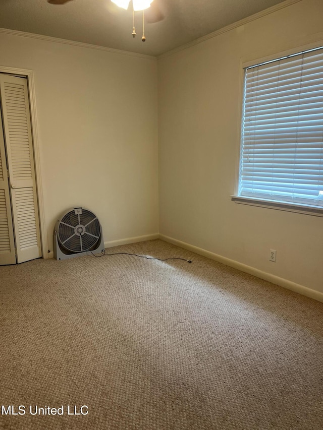 unfurnished room featuring carpet floors, crown molding, and baseboards