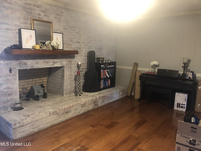 sitting room featuring a fireplace, ornamental molding, and wood finished floors