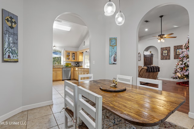 dining area featuring vaulted ceiling, ceiling fan, and light tile patterned flooring