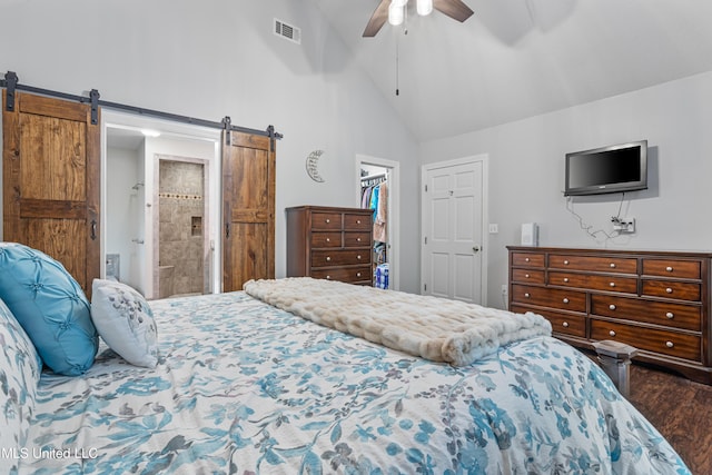 bedroom featuring high vaulted ceiling, hardwood / wood-style flooring, ceiling fan, a barn door, and a spacious closet