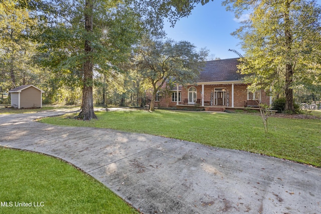 view of front of property featuring a front lawn and a storage unit