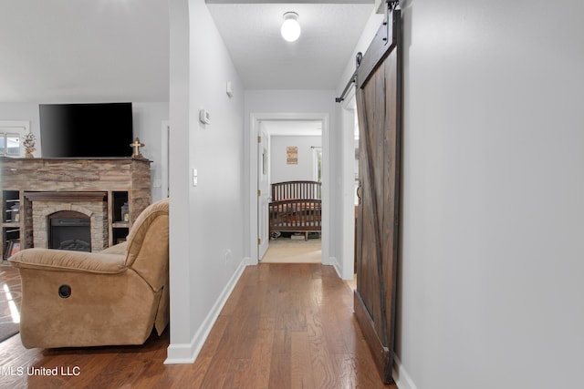 hallway featuring wood-type flooring and a barn door