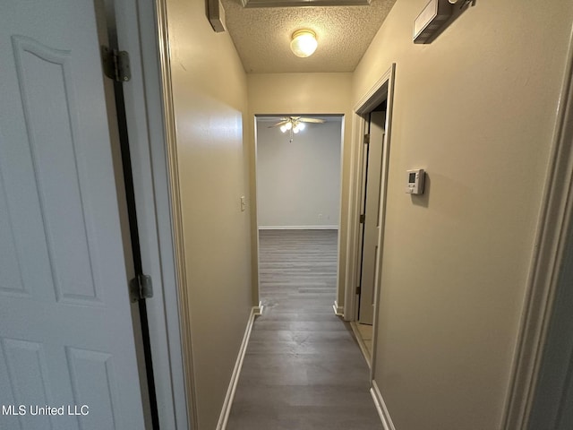 1664 Thomas St, Horn Lake, MS 38637 - corridor featuring a textured ceiling, baseboards, and wood finished floors