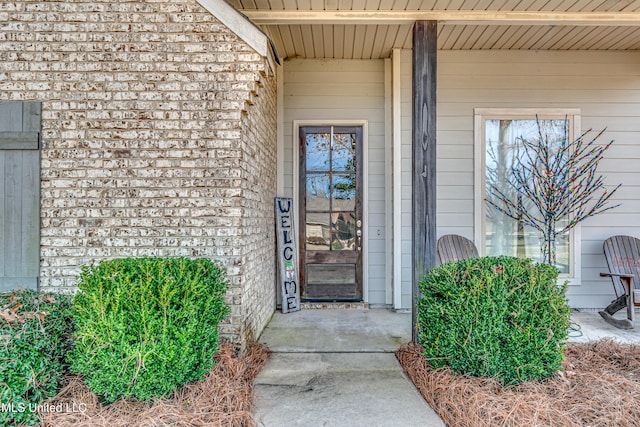 view of exterior entry with brick siding