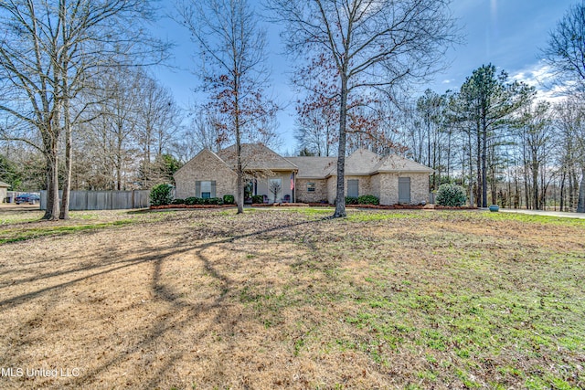 ranch-style house with fence and a front lawn