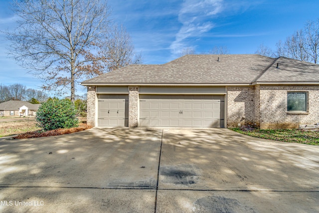 view of front of home with driveway, brick siding, an attached garage, and roof with shingles