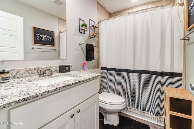 bathroom featuring curtained shower, visible vents, vanity, and toilet