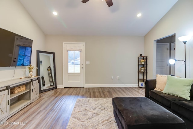 living area featuring lofted ceiling, ceiling fan, recessed lighting, baseboards, and light wood-type flooring