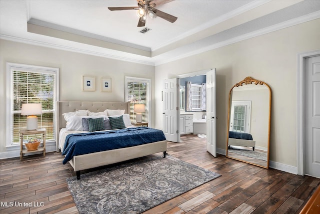 bedroom with connected bathroom, multiple windows, dark wood-type flooring, and ceiling fan