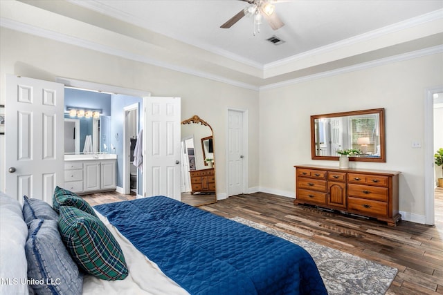 bedroom with ceiling fan, dark hardwood / wood-style flooring, crown molding, and connected bathroom