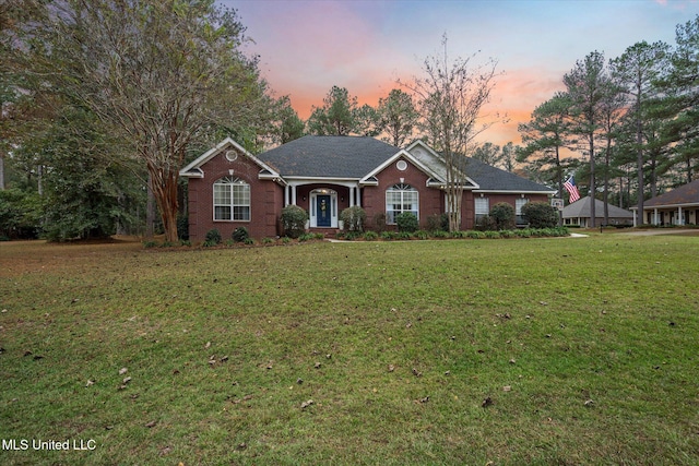 ranch-style home with a yard