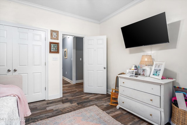 bedroom with a closet, dark hardwood / wood-style floors, and ornamental molding