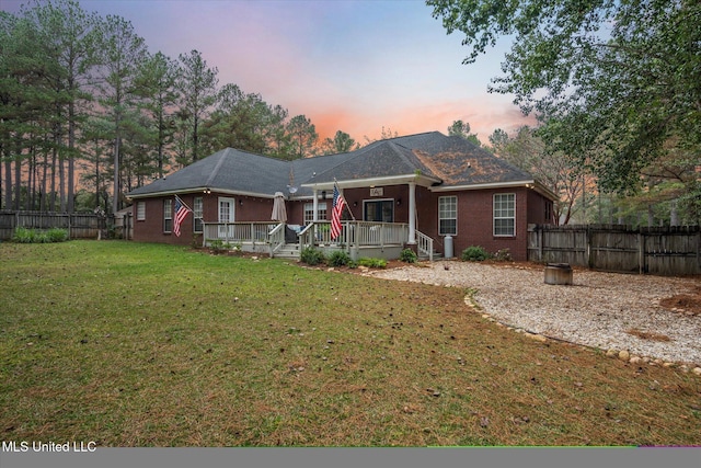 view of front of house featuring covered porch and a yard