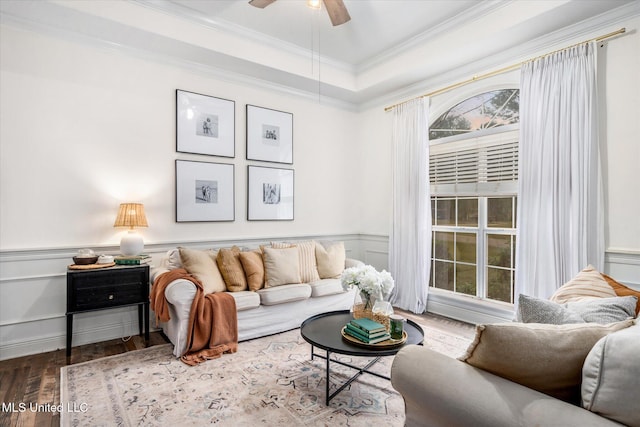 living room with a tray ceiling, crown molding, ceiling fan, and wood-type flooring