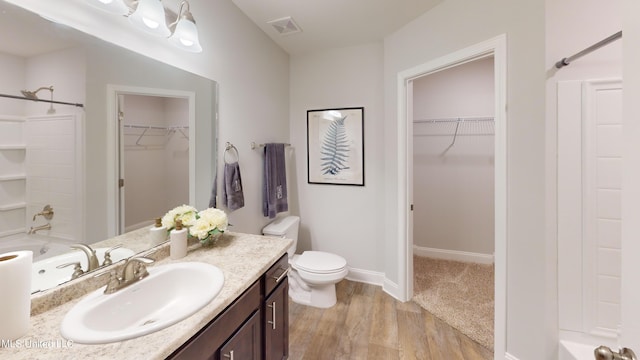 full bathroom with shower / bathing tub combination, vanity, hardwood / wood-style flooring, and toilet