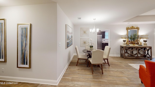 dining space featuring a notable chandelier and light wood-type flooring