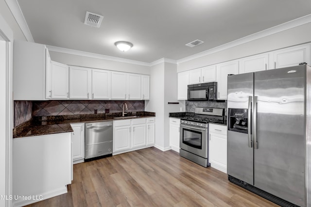 kitchen featuring a sink, dark countertops, visible vents, and stainless steel appliances