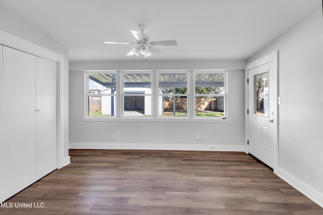 unfurnished bedroom featuring ceiling fan, baseboards, and wood finished floors