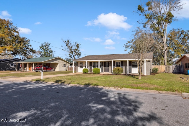 ranch-style home with fence, driveway, a porch, a front lawn, and a carport