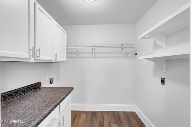 laundry room with dark wood-style floors, cabinet space, hookup for an electric dryer, and baseboards