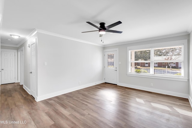 interior space featuring ceiling fan, baseboards, wood finished floors, and ornamental molding