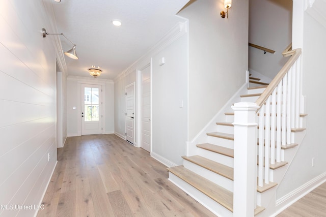 foyer featuring crown molding and light hardwood / wood-style floors