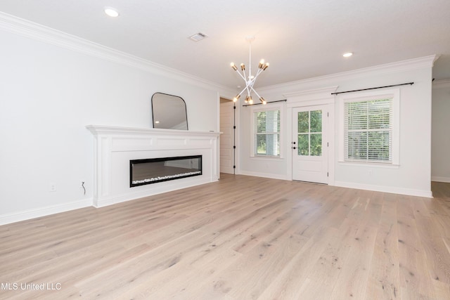 unfurnished living room featuring crown molding, an inviting chandelier, and light hardwood / wood-style floors