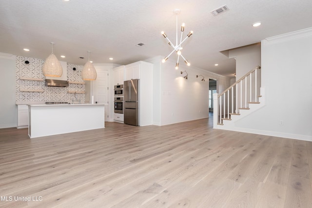 unfurnished living room with a notable chandelier, ornamental molding, and light hardwood / wood-style floors