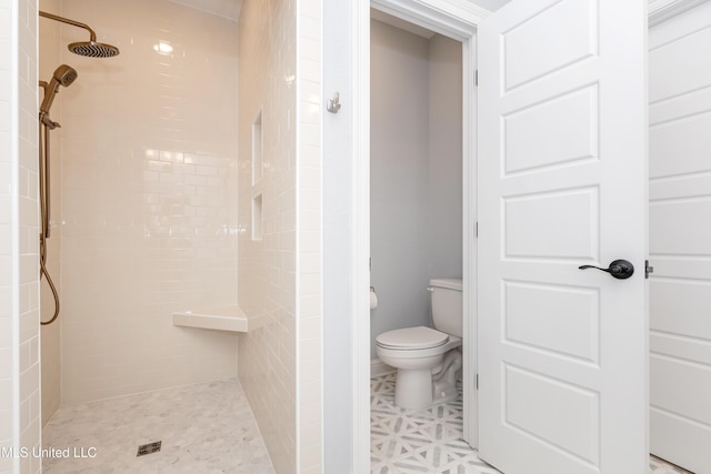 bathroom with tiled shower and toilet