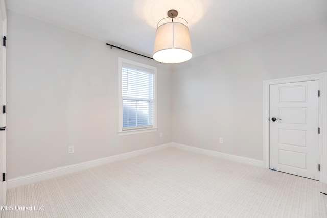 spare room featuring light colored carpet