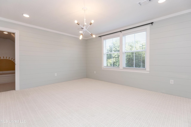 spare room featuring an inviting chandelier and wooden walls